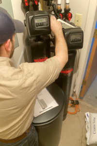Technician programming a Clack water softener control valve