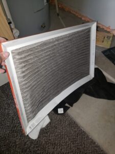 homeowner replacing an HVAC air filter