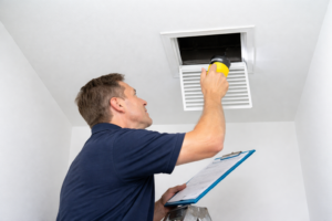 Technician inspecting residential HVAC ductwork