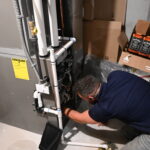 Technician checking furnace wiring and control components