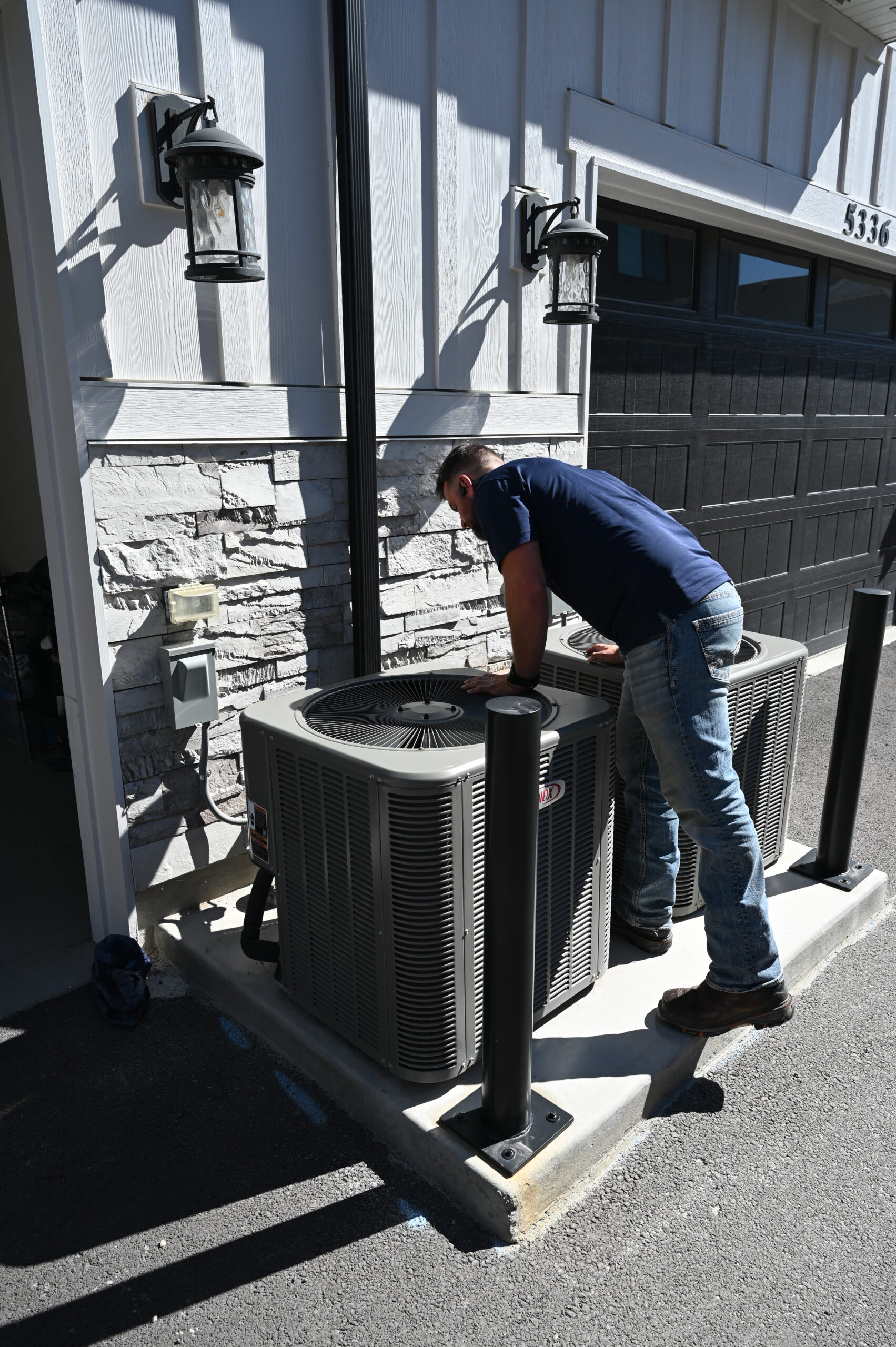 Technician verifying electrical components on an HVAC condenser
